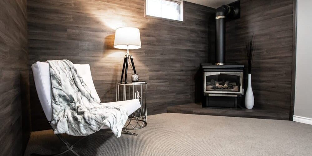 warm-basement-with-fireplace warm basement with chair, blanket, and fireplace