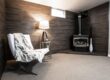 warm basement with chair, blanket, and fireplace